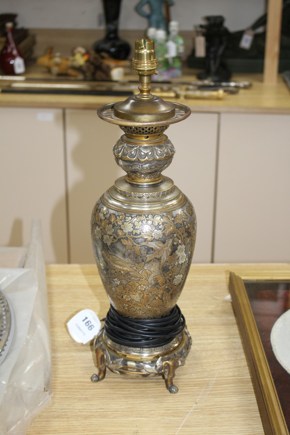 A 19th century French silvered and gilt brass table lamp, decorated with Oriental style flowers, scrolls and bamboo feet, overall heigh